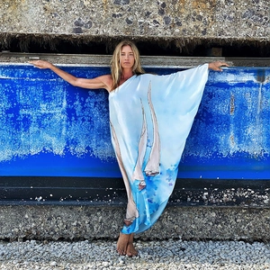 Nahaufnahme der Satin-Textur mit maritimem Segelboot-Druck auf dem blauen Kleid