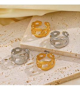 Detail of four chain-style adjustable rings in gold and silver finish on stone