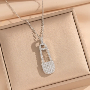 Detailed close-up of a silver safety pin necklace pendant set with sparkly cubic zirconia
