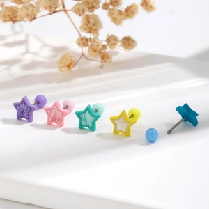 Five colorful sparkling star stud earrings with screw ball backs on a white surface