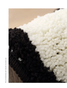 Close-up of high-density plush fiber texture in black and white minimalist rug