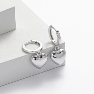 Detailed close-up of 925 sterling silver heart drop earrings on white geometric stands