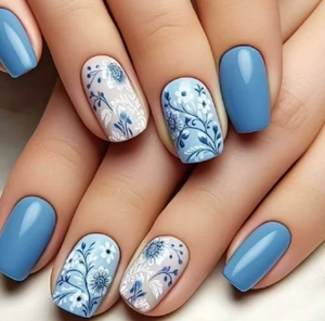 Close-up of blue floral press-on nails with minimalist plant patterns and matte finish