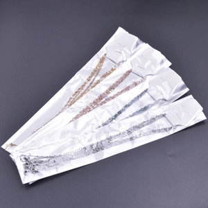 Close-up of four fashion necklaces in gold, rose gold, blue and silver on display cards
