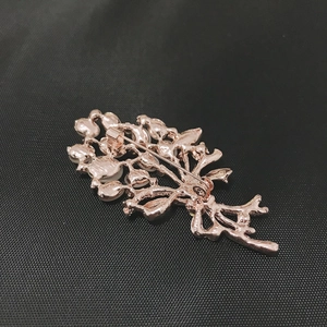 Detail of rose gold bouquet brooch back showing secure safety pin and metallic texture