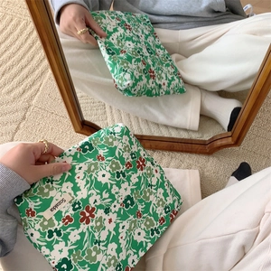 Mirror reflection showing front and back of green floral cotton canvas cosmetic bag