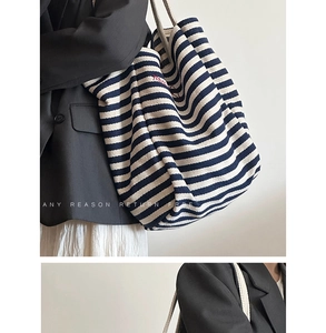 Detail of blue and white striped canvas tote bag with thick cotton rope handles