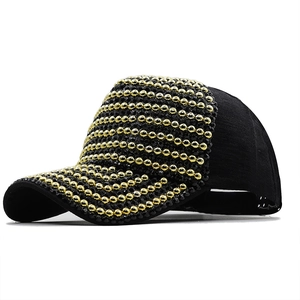 Close-up of black baseball cap featuring elegant gold and black pearl embellishments