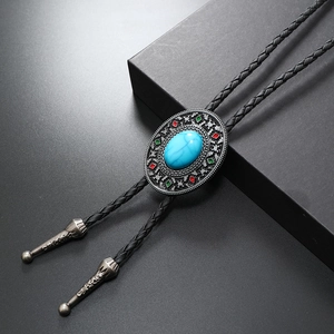 Vintage bolo tie with turquoise centerpiece and braided leather cord on black background