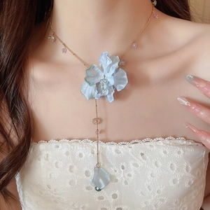 Detail of light blue organza flower necklace with crystal beads and long gold tassel