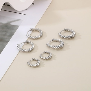 Detailed arrangement of silver stainless steel hoop earrings with beads in various sizes