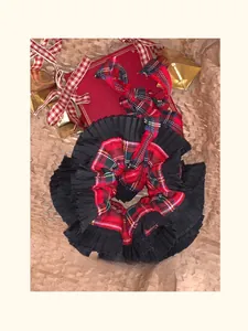 Detail of red and black plaid scrunchie with pleated edge and festive holiday ornaments