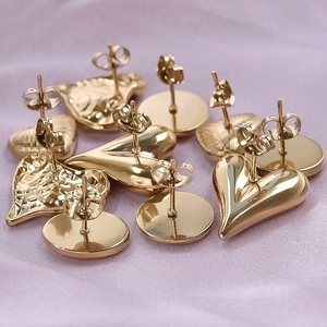 Detailed macro shot of golden 304 stainless steel heart and round stud earrings