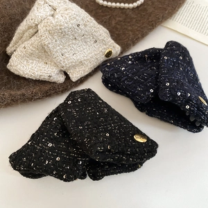 Detailed close-up of tweed hair clips with metallic buckle and sequins in various colors