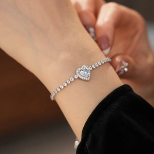 Close-up of heart-shaped zircon bracelet with silver-tone sparkling stones on wrist