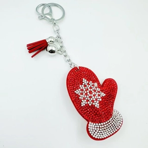 Detail of red glove keychain featuring crystal rhinestones, silver bell and tassel