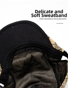 Close-up of the black sweatband and cotton lining inside the beige plaid newsboy cap