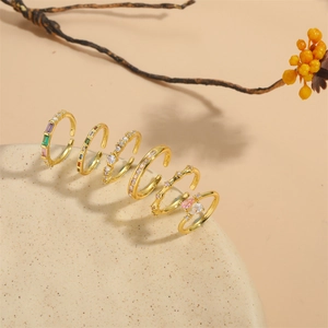 Set of 6 gold adjustable rings with colorful gemstones and zircon on a natural stone