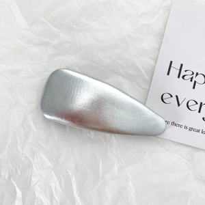 Close-up of silver PU leather y2k hair scrunchie with matte texture on white paper