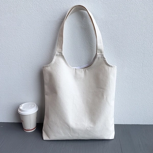 Close-up of minimalist plain beige canvas tote bag with sturdy shoulder straps