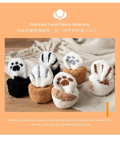 Close-up of thick coral fleece winter socks with cute cat paw patterns and fuzzy texture