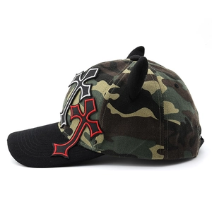 Detail of pink cross embroidery and devil horns on camouflage baseball cap
