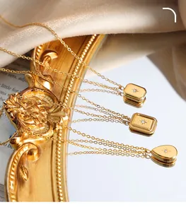 Detailed view of vintage 18K gold plated pendants with starburst zircon on satin fabric