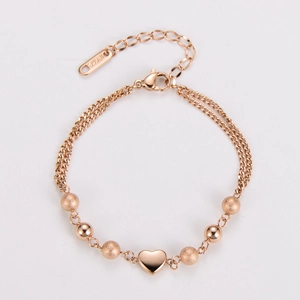 Detail of rose gold double-layer beaded bracelet with 18KGP heart pendants on white backdrop