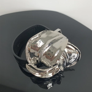 Detail van zilver vloeibaar metalen bloemaccent op zwarte leren armband