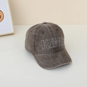 Dettaglio del ricamo KING sul cappellino da baseball per bambini in denim lavato