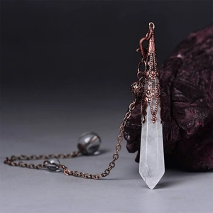 Macro detail of white crystal hexagonal prism pendant with vintage copper filigree cap