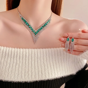 Detail der eleganten silbernen Quastenkette mit grünen Edelsteinen am Modell