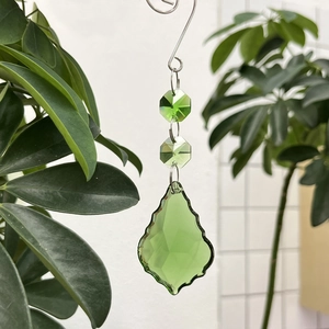 Close-up of green crystal suncatcher featuring faceted leaf pendant and octagonal beads