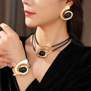 Detailed view of vintage gold spiral jewelry set with black stones worn by a model