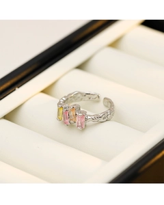 Detail of silver irregular ring with three rectangular pink and yellow gemstones