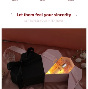 Detail of a hexagonal gift box with a pink ribbon, raffia filling, and warm LED lights