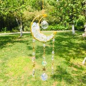 Detail of golden moon suncatcher with clear natural stones and hanging crystal prisms
