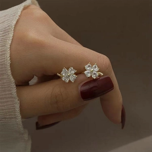 Elegant gold four-leaf clover ear cuffs with heart-shaped white cubic zirconia stones