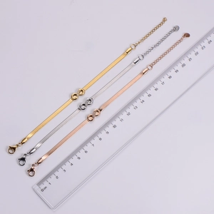 Three colors of stainless steel infinity snake chains next to a ruler for size measurement