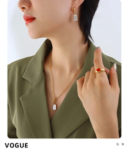 Gros plan sur collier et boucles d'oreilles dorés avec pendentifs en nacre