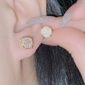 Macro shot of gold micro-pave round stud earrings with shimmering clear cubic zirconia