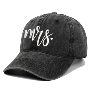 Close-up of white 3D Mrs. embroidery on vintage washed black baseball cap fabric