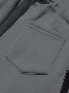 Detail of grey fleece joggers featuring a zip patch pocket and knit fabric texture