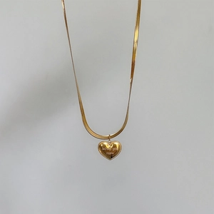 Gold heart pendant necklace with love you more engraving on a flat snake chain