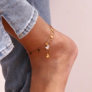 Double-layer gold anklet with heart pendants and white shell inlay worn with jeans