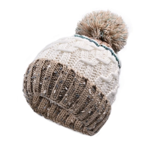 Détail d'un bonnet en grosse maille avec un pompon contrasté et une texture épaisse