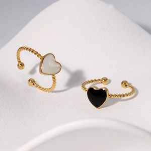 Detail of gold open rings with heart-shaped inserts and twisted rope texture design