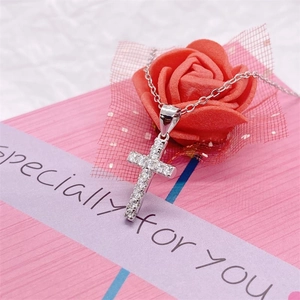 Macro shot of S925 sterling silver cross necklace with pavé zircons in a pink gift box