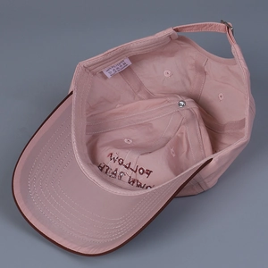 Internal view of pink baseball cap showing polyester fabric and embroidered slogan