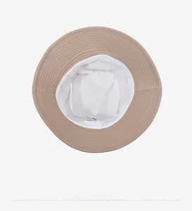 Interior detail of beige bucket hat showing white lining and reinforced stitching